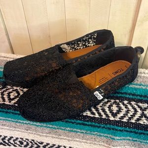 Black lace Tom’s slip ons